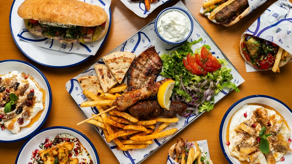 A table of pita, grill platters, fries and dips at MyPita